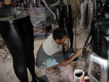 Seorang pekerja menyelesaikan pembuatan maneken di Kebon Jeruk, Jakarta Barat, Senin (28/12/2020). Maneken yang terbuat dari bahan viber tersebut dijual dengan harga Rp 1 juta. (merdeka.com/Dwi Narwoko)