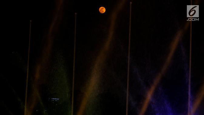 Penampakan bulan purnama di tengah air mancur yang menghiasi lanagit kawasan Jakarta, Jumat (13/9/2019). Malam hari ini, masyarakat bisa melihat bulan purnama yang dinamai Harvest Moon karena bulan mencapai kecerahan puncak dekat dengan titik balik musim semi. (Liputan6.com/Johan Tallo)