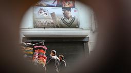 Orang-orang membeli pakaian dari kios-kios yang didirikan di luar gedung bioskop di New Delhi (29/12/2021). Pemerintah Delhi memberlakukan pembatasan fasilitas seperti gedung bioskop, multipleks, dan gym, dan lainya untuk mengekang lonjakan virus corona Covid-19. (AFP Photo/Sajjad Hussain)