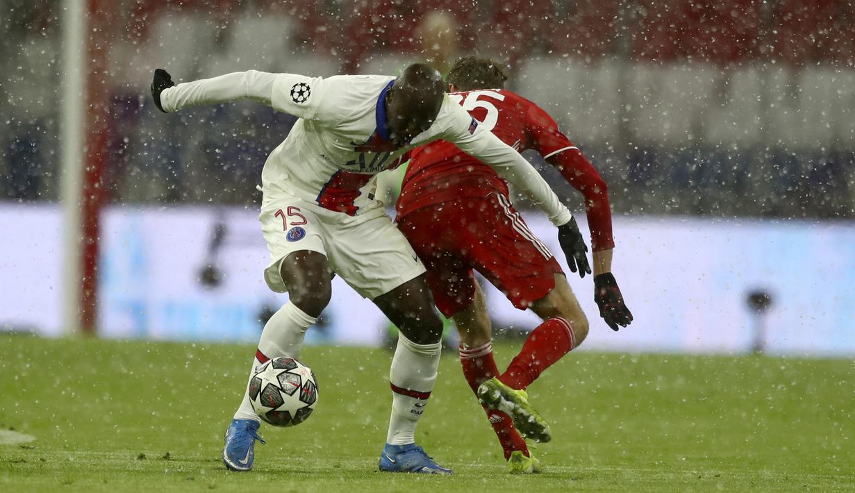 Gelandang Paris Saint-Germain (PSG), Danilo Pereira dan penyerang Bayern Munchen, Thomas Mueller berebut bola pada leg pertama perempat final Liga Champions di Allianz Arena, Kamis (8/4/2021). PSG melakukan pembalasan yang sempurna saat menang 3-2 atas Bayern Munchen. (AP Photo/Matthias Schrader)