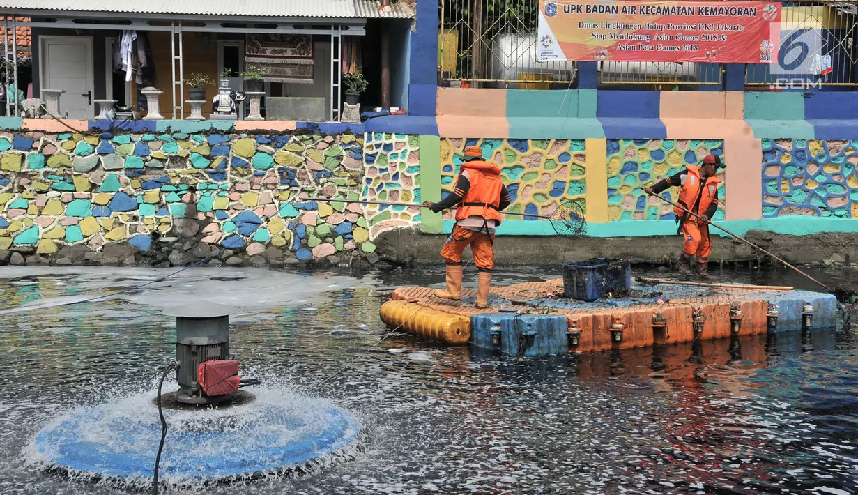 Petugas PPSU membersihkan sampah saat pengoperasian Nano Bubble dan Aerator di Kali Item, Jakarta, Kamis (2/8). Berbagai cara, dari pemberian oksigen melalui pengoperasian Nano Bubble dan Aerator hingga penyedotan 24 jam. (Merdeka.com/Iqbal S. Nugroho)