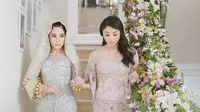 Nikita Willy (kiri) didampingi sang adik (kanan) menuju prosesi Malam Bainai (dok. Instagram @thebridestory/ Photographer: Axioo, Andreas Hartanto)