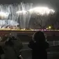 Sejumlah warga melihat kembang api dari jauh saat upacara penutupan Olimpiade Musim Dingin 2022, di Stadion Nasional, Beijing, China, Minggu (20/2/2022). (AP Photo/Natacha Pisarenko)