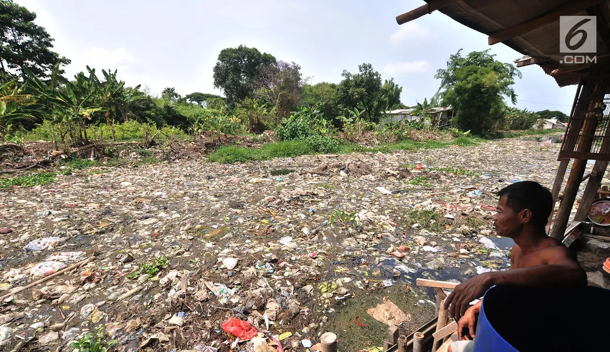 Warga melihat Kali Pisang Batu yang dipenuhi sampah, Tarumajaya, Bekasi, Jawa Barat, Rabu (9/1). Warga tetap beraktivitas sehari-hari meski bau tak sedap menghantui mereka akibat tumpukan sampah di Kali Pisang Batu. (Merdeka.com/Iqbal S. Nugroho)