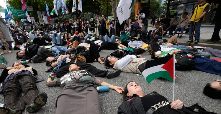 Sejumlah warga yang menyatakan solidaritas terhadap Palestina berbaring di jalan saat mengikuti aksi yang mengecam tindakan militer Amerika Serikat dan Israel di Gaza, di Seoul, Korea Selatan, Sabtu (3/10/2026). Aksi die-in tersebut dilakukan sebagai simbol untuk menggambarkan korban konflik di Gaza. Para peserta berkumpul dan menyampaikan dukungan terhadap Palestina dalam unjuk rasa yang berlangsung di kawasan pusat Kota Seoul. (AP Photo/Ahn Young-joon)
