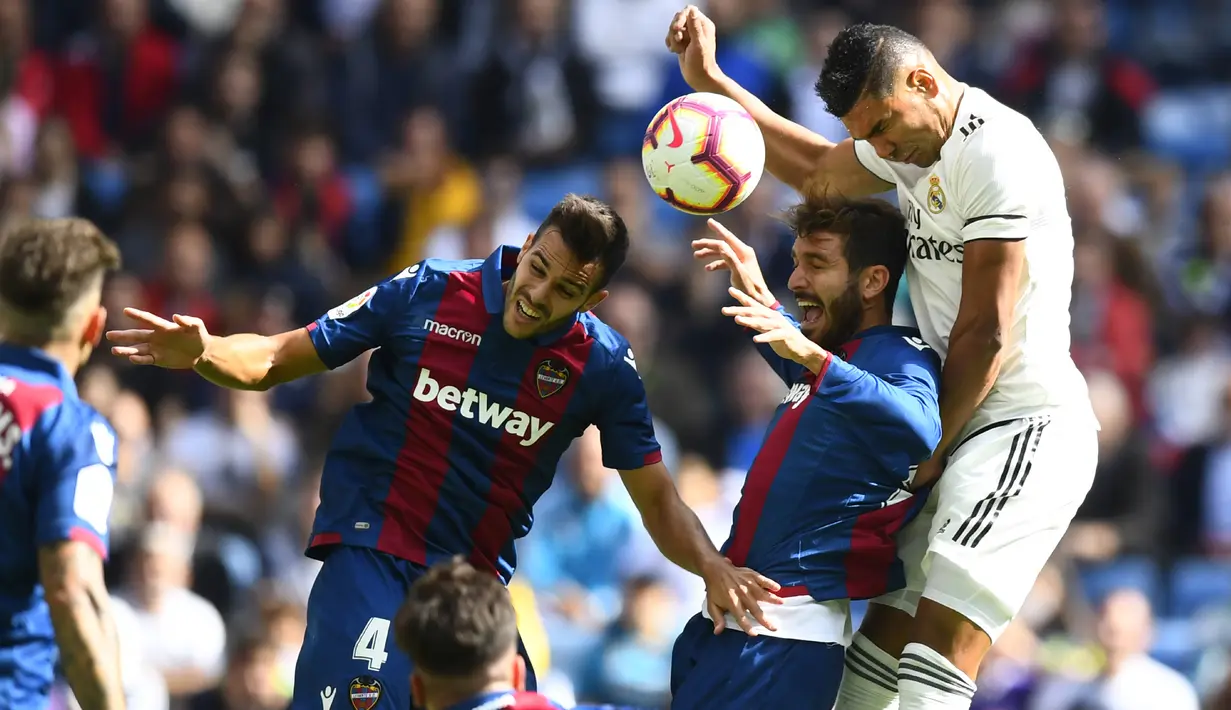 Bek Levante, Roberto Suarez, duel udara dengan gelandang Real Madrid, Casemiro, pada laga La Liga Spanyol di Stadion Santiago Bernabeu, Madrid, Sabtu (20/10). Madrid kalah 1-2 dari Levante. (AFP/Gabriel Bouys)
