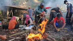 Warga membakar ayam untuk disantap bersama dalam tradisi Sadranan di Sendang Gede Pucung, Pudakpayung, Semarang, Jumat (12/4). Tradisi turun temurun membersihkan mata air dilanjutkan berdoa dan makan bersama itu simbol penyucian desa dalam rangka menyambut bulan suci Ramadan. (Liputan6.com/Gholib)