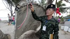 Tentara memeriksa potongan pesawat yang ditemukan di pantai Thailand selatan, provinsi Nakhon Si Thammarat, Minggu (24/1). Sebuah bagian pesawat yang diduga dari pesawat Malaysia Airlines MH370 ditemukan oleh warga sekitar. (REUTERS/Surapan Boonthanom)