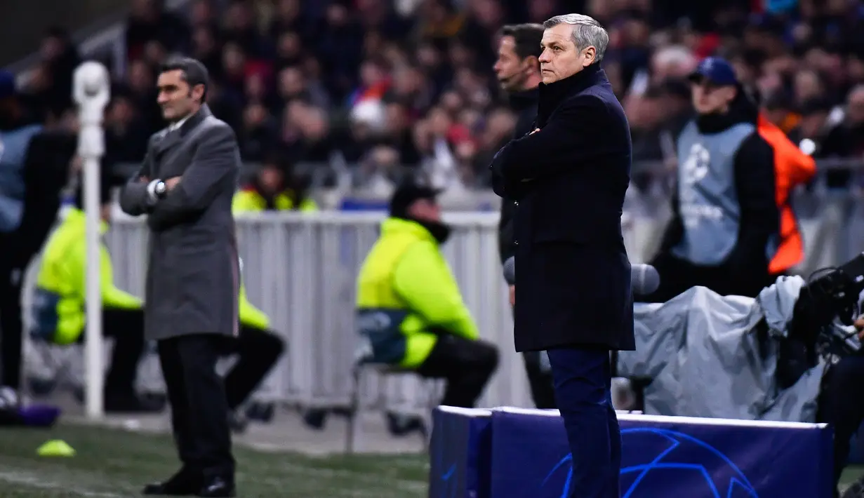 Pelatih Lyon Bruno Genesio (kanan) berdiri di sebelah pelatih Barcelona Ernesto Valverde (kiri) selama pertandingan leg pertama babak 16 besar Liga Champions di Decines, Lyon, Prancis, Selasa (19/2). Laga berakhir 0-0. (JEFF PACHOUD/AFP)