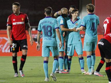 Para pemain Barcelona merayakan gol yang dicetak oleh Lionel Messi ke gawang Mallorca pada laga La Liga di Estadio de Son Moix, Minggu (14/6/2020). Barcelona menang dengan skor 4-0. (AP/Francisco Ubilla)