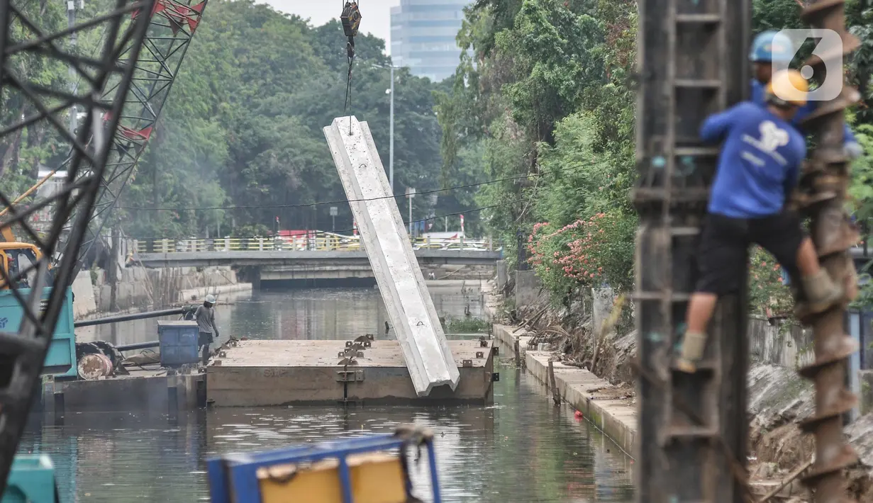Pekerja dari Dinas Sumber Daya Air (SDA) Provinsi DKI Jakarta menggunakan kendaraan alat berat saat menyelesaikan proyek normalisasi Kali Ciliwung di Jalan Gunung Sahari, Jakarta Pusat, Senin (22/8/2022). Pemprov DKI Jakarta melalui Dinas SDA memastikan program normalisasi Kali Ciliwung terus berjalan dengan prioritas di lokasi aliran utama sungai dan tujuh kelurahan yang merupakan titik rawan banjir. (merdeka.com/Iqbal S. Nugroho)