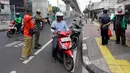 Pengendara motor pergi seusai diberi hukuman push up karena tidak memakai masker saat razia Pembatasan Sosial Berskala Besar (PSBB) di Kawasan Jalan Fatmawati, Jakarta, Selasa (28/4/2020). Penertiban terkait pelaksanaan PSBB Jakarta dan memutus rantai penyebaran COVID 19. (merdeka.com/Imam Buhori)