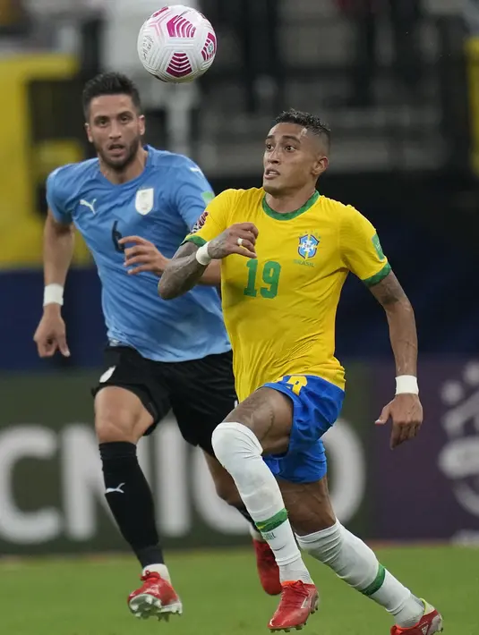 Pemain Brasil Raphinha (kanan) dan pemain Uruguay Rodrigo Bentancur memperebutkan bola pada pertandingan kualifikasi Piala Dunia 2022 di Arena da Amazonia, Manaus, Brasil, Kamis (14/10/2021). Brasil menang 4-1. (AP Photo/Andre Penner)