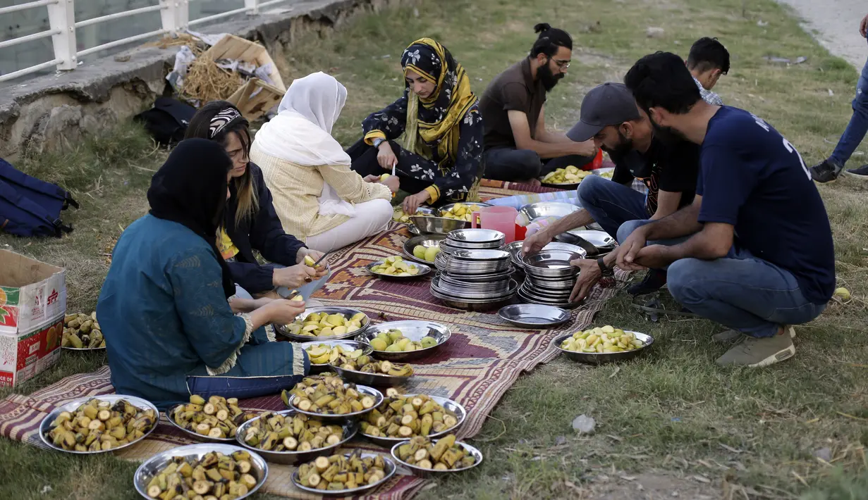 Relawan menyiapkan makanan dan buah untuk dibagikan kepada orang-orang yang berbuka puasa di pinggir jalan di Islamabad, Pakistan, 5 April 2022. Umat Muslim di seluruh dunia menjalankan Ramadhan, di mana mereka menahan diri dari makan, minum, merokok dan seks dari fajar hingga senja. (AP/Rahmat Gul)