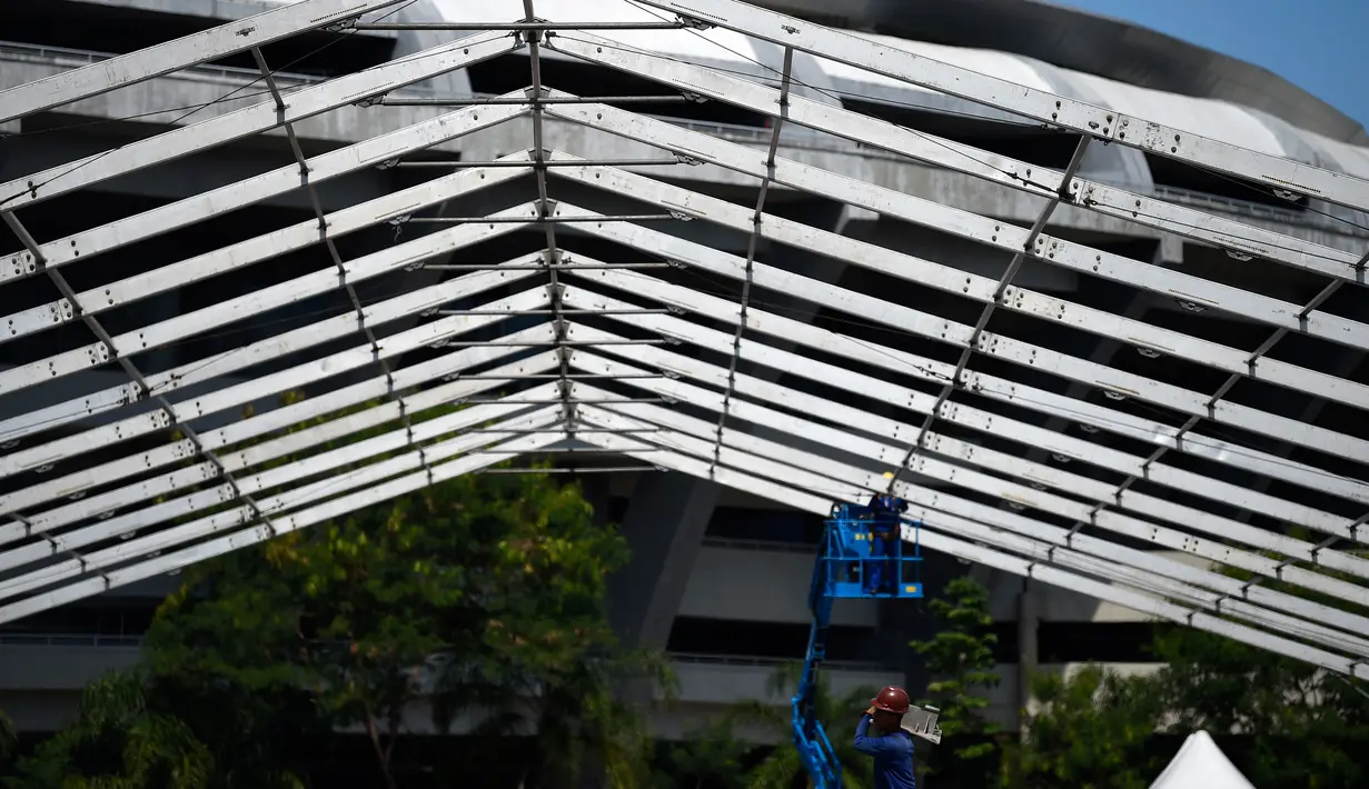 Pekerja memulai pembangunan rumah sakit darurat bagi pasien terinfeksi Covid-19 di kompleks stadion Maracana, Rio de Janeiro, Kamis (2/4/2020). Sebagian kompleks stadion paling terkenal di Brasil itu diubah menjadi rumah sakit lapangan selama pandemi Covid-19. (MAURO PIMENTEL/AFP)