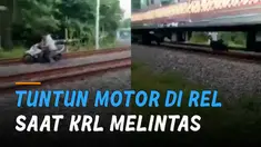 Aksi ngawur dilakukan oleh seorang pria ketika tuntun motor di rel saat KRL melintas.