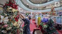 Pekerja merapikan pernak-pernik Natal di Mal Artha Graha, Jakarta, Sabtu (4/12/2021). Jelang perayaan Natal 25 Desember sejumlah mal di ibukota mulai menjual berbagai kebutuhan Natal mulai dari pernak-pernik hingga pohon Natal dengan kisaran harga Rp10.000-Rp5 juta. (Liputan6.com/Faizal Fanani)