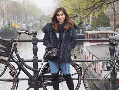 Gaya Nisya Ahmad saat berlibur di Amsterdam, Belanda pun tetap terlihat stylish. Ia memilih menggunakan jaket berwarna hitam yang dipadukan dengan syal serta tas dan sepatu berwarna senada. (Liputan6.com/IG/@nissyaa)