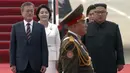 Presiden Korea Selatan, Moon Jae-in didampingi istrinya Kim Jung-sook berjalan bersama pemimpin Korea Utara, Kim Jong-un didampingi sang istri, Ri Sol Ju setibanya di Pyongyang, Selasa (18/8). (Korea Broadcasting System via AP)