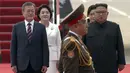 Presiden Korea Selatan, Moon Jae-in didampingi istrinya Kim Jung-sook berjalan bersama pemimpin Korea Utara, Kim Jong-un didampingi sang istri, Ri Sol Ju setibanya di Pyongyang, Selasa (18/8). (Korea Broadcasting System via AP)