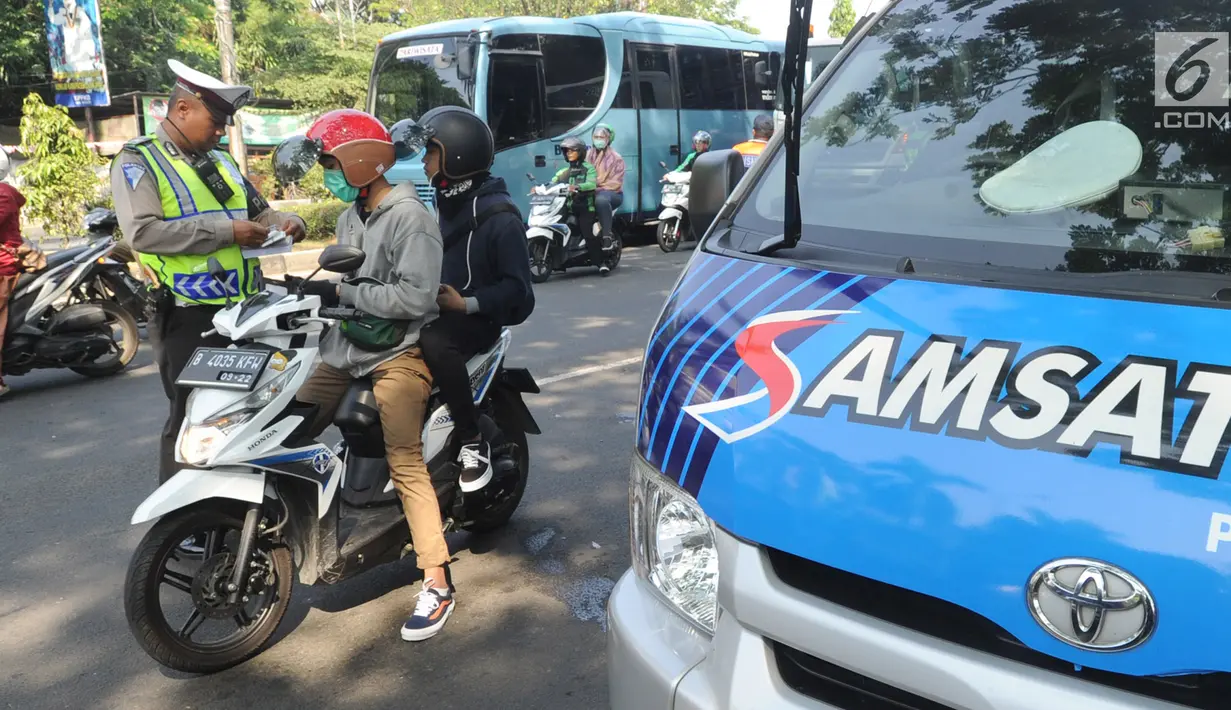 Petugas kepolisian memeriksa kelengkapan dokumen pengendara sepeda motor saat melakukan razia gabungan di kawasan Naggewer,  Bogor, Selasa (18/9). Razia itu menyasar pemilik kendaraan yang belum membayar pajak kendaraan. (Merdeka.com/Arie Basuki)