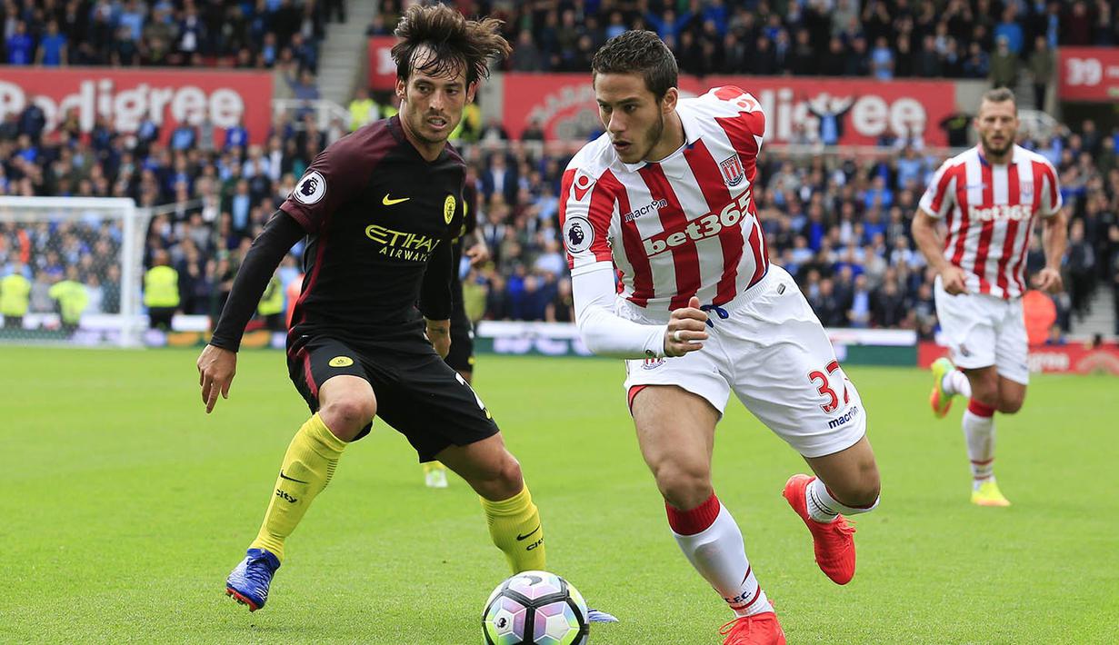 Gelandang Stoke, Ramadan Sobhi, berusaha melewati gelandang Manchester City, David Silva. City menguasai jalannya laga dengan penguasaan bola 58 persen. (AFP/Lindsey Parnaby)