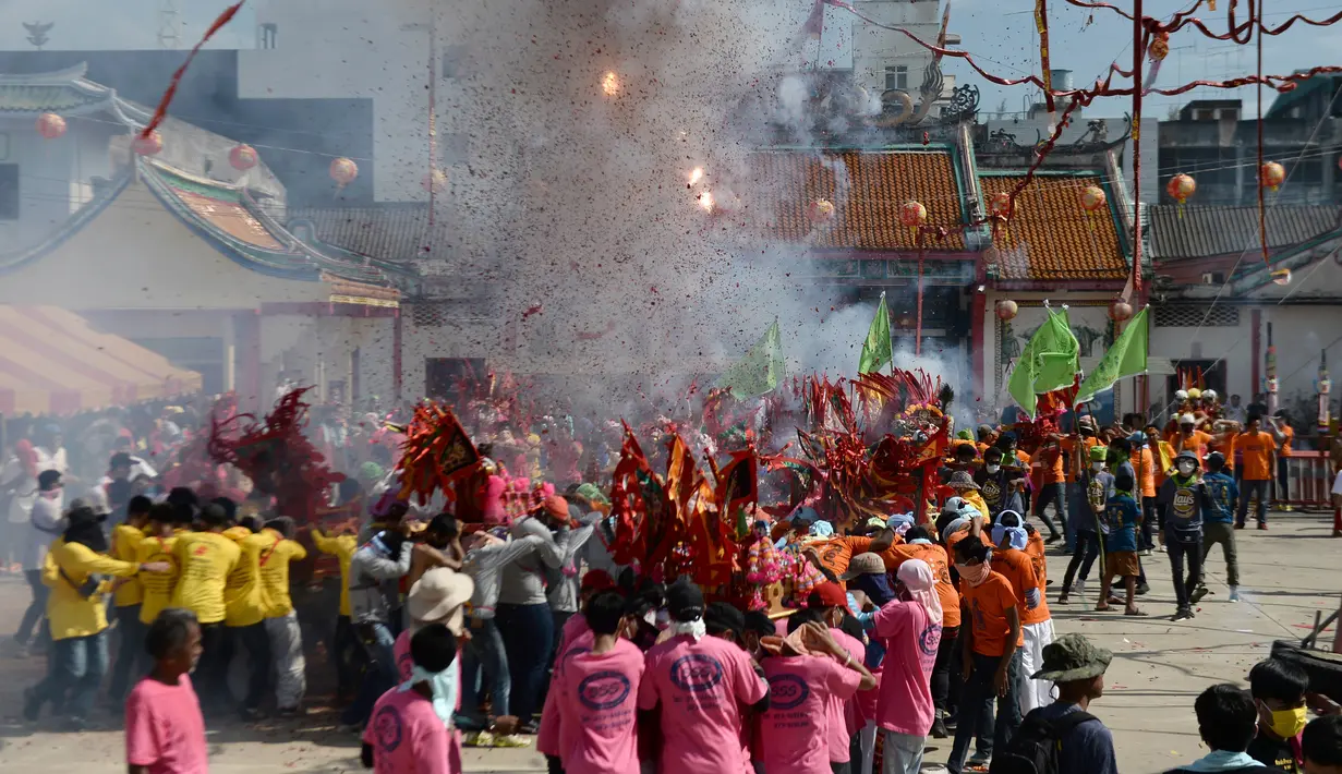 Sejumlah warga menyalakan petasan saat merayakan festival keagamaan tahunan untuk Dewi yang sangat dihormati dari Kuil Chao Mae To Mo di distrik Sungai Kolok, Thailand (8/5). (AFP/Madaree Tohlala)