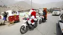 Seorang polisi Peru berpakaian seperti Santa Claus tiba dengan sepeda motornya selama perayaan Natal di Huaycan, Lima, Peru (15/12/2015). (REUTERS/Janine Costa)