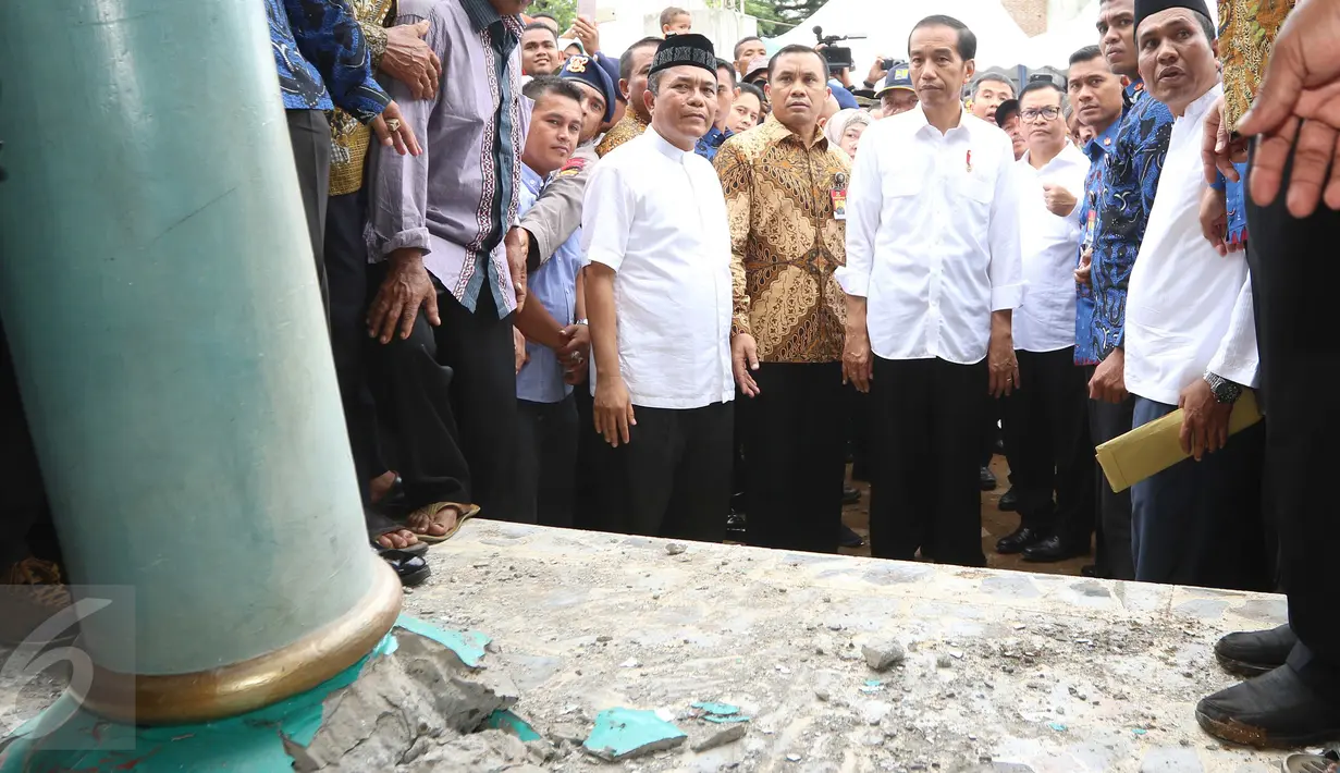 Presiden Joko Widodo (Jokowi) mengamati kondisi Masjid At-Taqarrub yang rusak parah di Pidie Jaya, Aceh, Jumat (9/12). Jokowi meminta agar masjid yang rusak akibat gempa Aceh tersebut segera dibersihkan dan dibangun kembali. (Liputan6.com/Angga Yuniar)