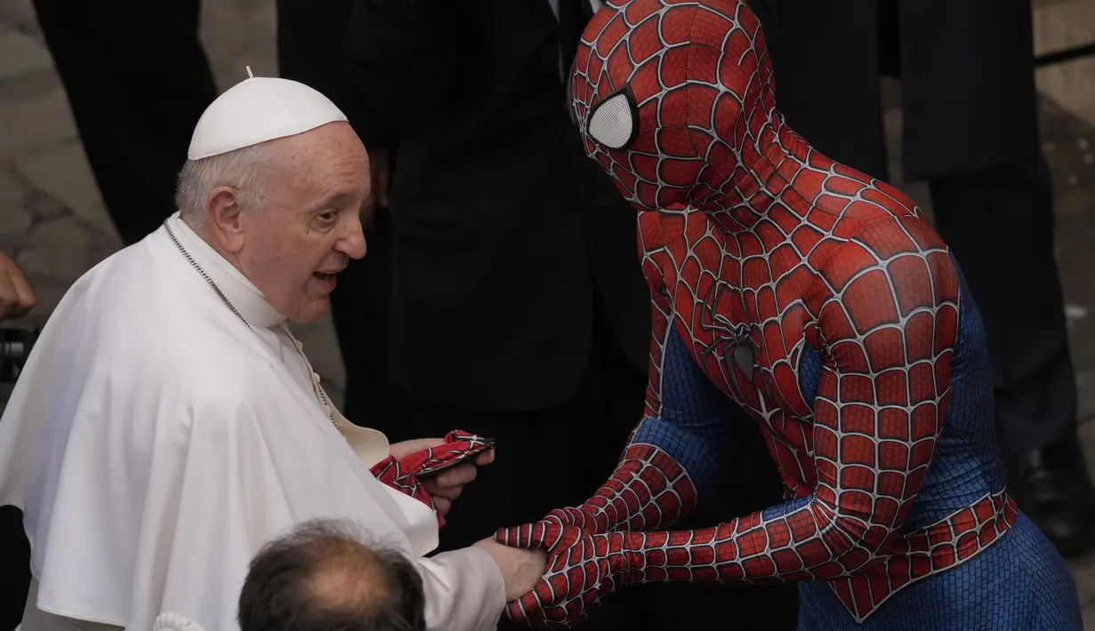 Paus Fransiskus bertemu Spider-Man pada akhir audiensi umum mingguan dengan jumlah umat terbatas di San Damaso Courtyard, Vatikan, Rabu (23/6/2021). Di akhir audiensi, pria tersebut diperkenalkan kepada Paus Fransiskus dan memberi masker Spider-Man miliknya. (AP Photo/Andrew Medichini)
