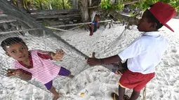 Anak-anak suku Byak Betew bermain di tepi pantai di pulau Saukabu, satu dari 1.500 pulau di Raja Ampat 20 Agustus 2017. Raja Ampat merupakan rumah bagi sekitar 1.400 jenis ikan dan 600 spesies karang. (AFP Photo/Goh Chai Hin)