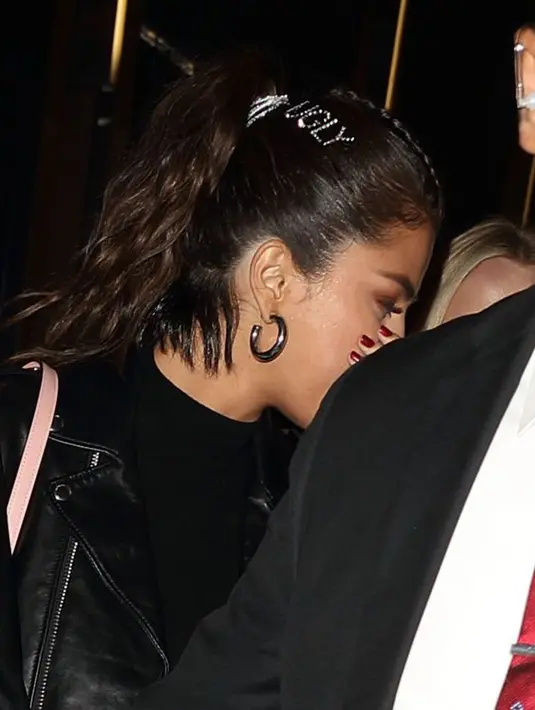 Selena Gomez terpotret menggunakan jepit rambut dengan tulisan "UGLY" berukuran besar. (SPLASH NEWS/Cosmopolitan)