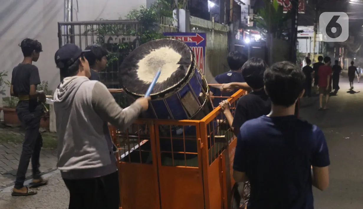 Sejumlah remaja melakukan pukul bedug keliling kampung di Karang Tengah,Tangerang, Banten, Rabu (29/4/2020). Pukul bedug keliling merupakan tradisi membangunkan warga untuk sahur pada bulan Ramadan. (Liputan6.com/Angga Yuniar)