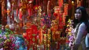Seorang wanita melihat-lihat dekorasi Tahun Baru Imlek atau perayaan Tet di sebuah pasar pusat Kota Tua Hanoi, Senin (28/1). Setiap perayaan imlek, warga Vietnam akan menghias rumah dengan berbagai dekorasi berwarna merah. (Manan VATSYAYANA/AFP)