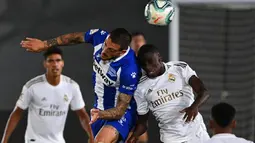 Penyerang Alaves, Joselu berebut bola dengan bek Real Madrid, Ferland Mendy pada lanjutan Liga Spanyol di stadion Alfredo di Stefano, Sabtu (11/7/2020). Real Madrid menang 2-0 lewat gol Karim Benzema dan Marco Asensio. (GABRIEL BOUYS/AFP)