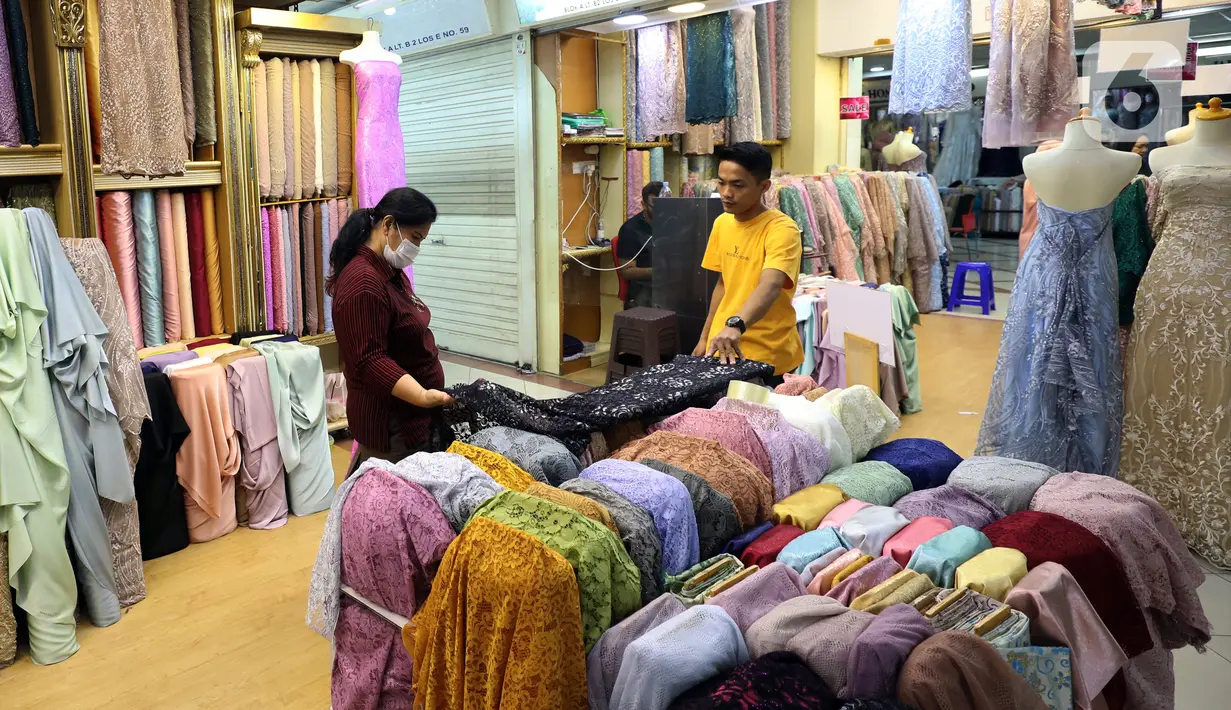 Pedagang kain bahan melayani pembeli di Pasar Tanah Abang, Jakarta, Rabu (18/5/2022). Kementerian Perindustrian memproyeksikan industri tekstil dan produk tekstil (TPT) bakal tumbuh 3,5 persen pada semester I/2022. (Liputan6.com/Angga Yuniar)