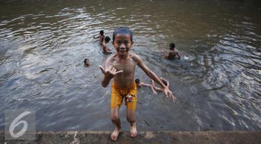 Sejumlah anak mandi di Sungai Ciliwung, Jakarta, Rabu (16/11). Cuaca panas di Jakarta membuat anak-anak tersebut mandi di sungai untuk mendinginkan suhu tubuh. (Liputan6.com/Gempur M Surya)