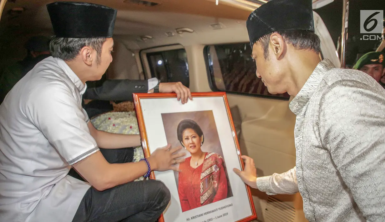 Agus Harimurti Yudhoyono dan Edhie Baskoro Yudhoyono membawa pigura foto almarhumah Ani Yudhoyono di Lanud Halim Perdanakusumah, Jakarta Timur, Sabtu (1/6/2019). Almarhumah meninggal dunia di National University Hospital (NUH) Singapura dan disemayakamkan di Puri Cikeas. (Liputan6.com/Faizal Fanani)
