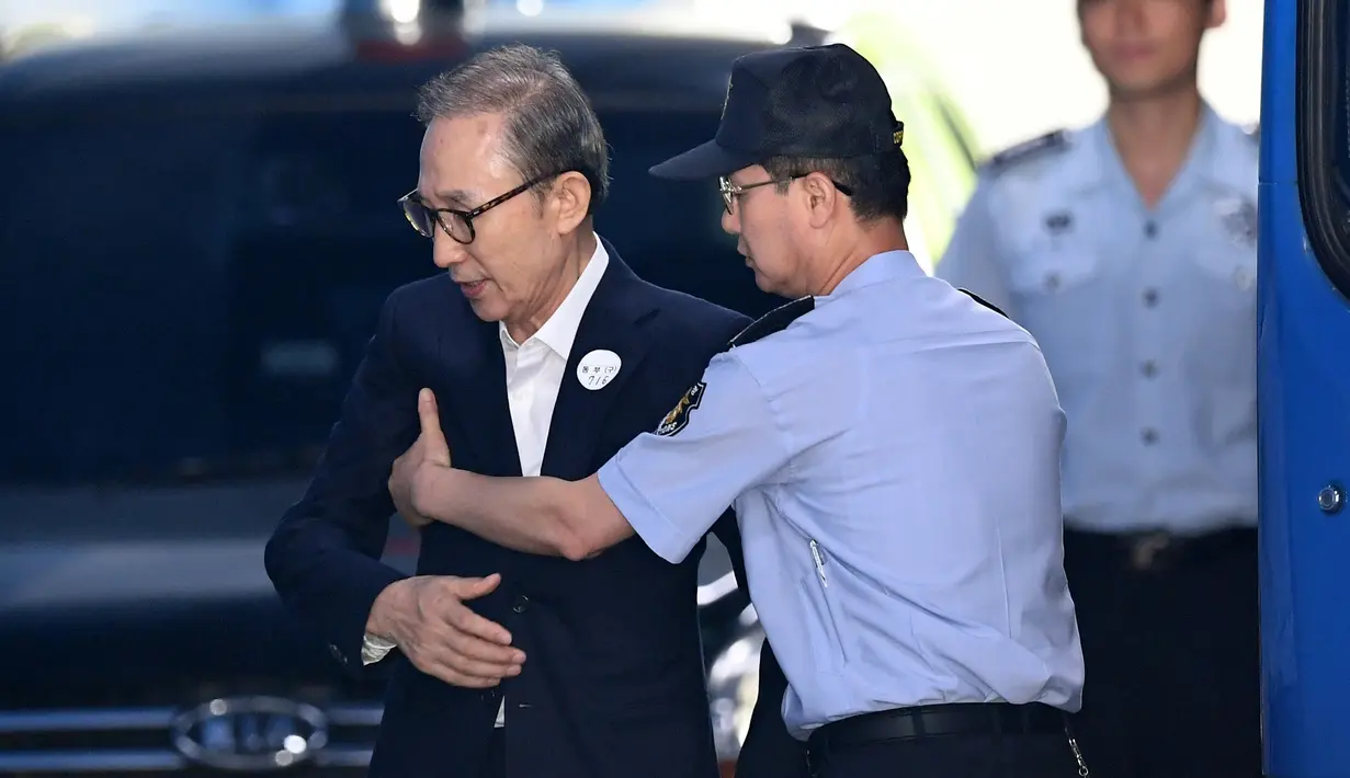 Mantan presiden Korea Selatan Lee Myung-bak (kiri) diperiksa petugas penjara ketika tiba di pengadilan untuk menghadiri persidangan di Seoul (6/9). Jaksa menuntut 20 tahun penjara Lee Myung-bak atas tuduhan korupsi. (AFP Photo/Jung Yeon-je)
