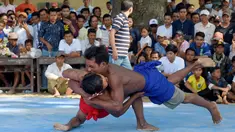 Dua pria bertarung gulat Khmer selama festival Pchum Ben atau festival kematian di desa Vihear Suor, provinsi Kandal (9/10). Warga Kamboja turun dari desa kecil di timur laut ibu kota untuk menyaksikan pertarungan ini. (AFP Photo/Tang Chhin Sothy)