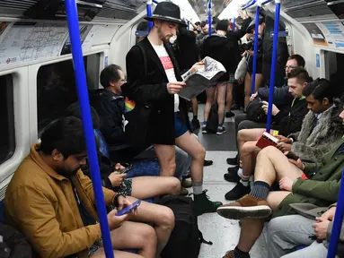 Orang-orang mengambil bagian dalam 'No Trousers On The Tube Day' atau No Pants Subway Ride di London Underground,  pusat Kota London, Minggu (12/1/2020). Untuk tahun ini, acara naik kereta tanpa celana itu dilangsungkan serentak di sejumlah kota dunia pada 12 Januari. (DANIEL LEAL-OLIVAS/AFP)