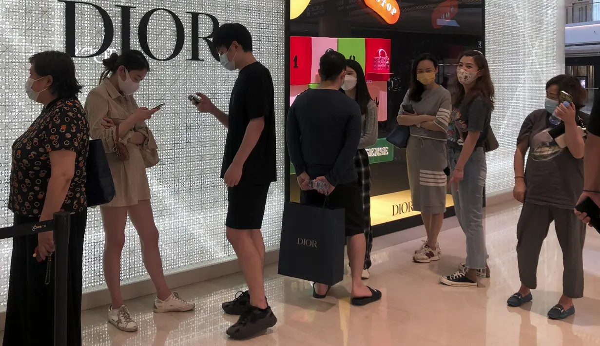 Pembeli berbaris untuk mengunjungi toko ritel mewah di pusat perbelanjaan yang dibuka kembali setelah ditutup berbulan-bulan di Shanghai,  Minggu (29/5/2022). Pembukaan kembali sebagian toko dan kantor di Beijing disambut oleh penduduk yang lelah dan pemilik toko yang berjuang untuk hidup kembali normal. Ditambah dengan pelonggaran pembatasan secara bertahap di Shanghai, itu menandakan bahwa yang terburuk telah berakhir dalam wabah kembar di kota-kota paling terkemuka di China. (AP Photo/Chen Si)