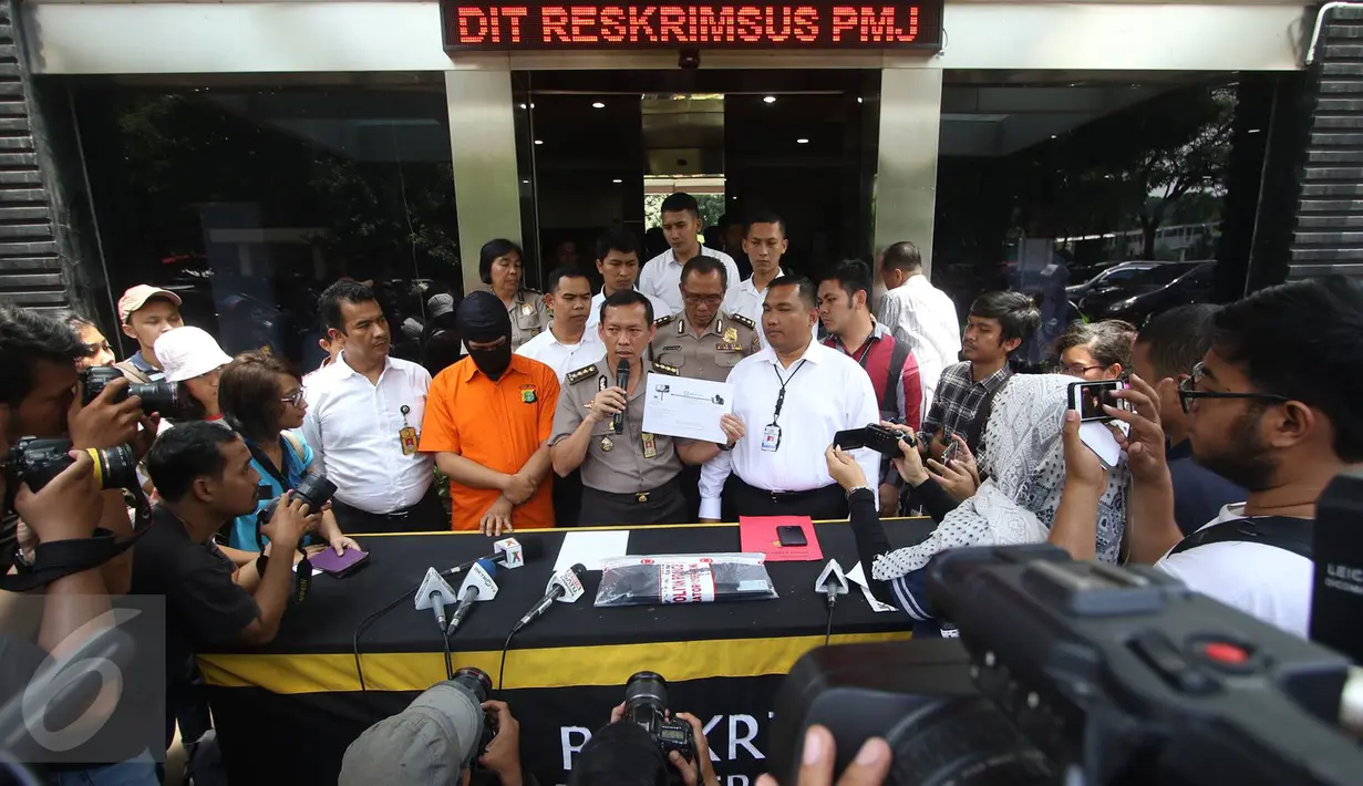 Kabid Humas Polda Metro Jaya Kombes Awi Setiyono menunjukkan barang bukti serta tersangka kasus videotron porno di Prapanca, Kebayoran Baru, berinisal SAR, saat rilis kasus videotron di Polda Metro Jaya, Rabu (5/10). (Liputan6.com/Immanuel Antonius)
