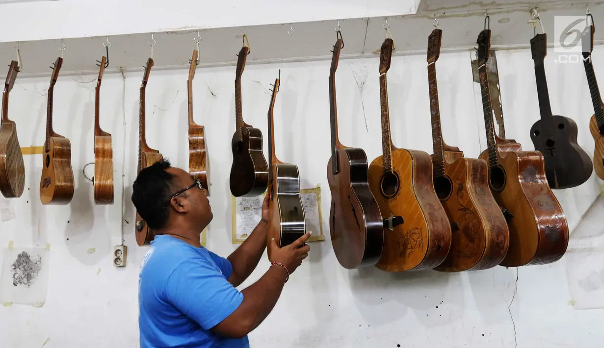 Pekerja tengah merapikan gitar di workshop I Wayan Tuges gitar berlabel Blueberry di Jalan Baruna No. 5 Guwang, Sukowati, Bali, Senin (15/10). Gitar tersebut banyak dipesan oleh musisi lokal hingga mancanegara. (Liputan6.com/Angga Yuniar)