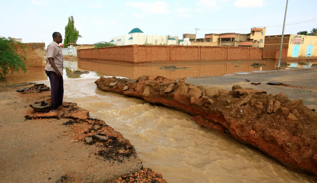 Seorang warga berdiri di dekat jalan yang tergenang banjir di Khartoum, Sudan (3/8/2020). Sudan dilanda banjir baru-baru ini akibat hujan lebat. (Xinhua/Mohamed Khidir)