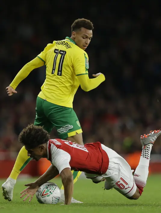 Pemain Arsenal, Reiss Nelson (bawah) terjatuh saat berebut bola dengan pemain Norwich City, Josh Murphy pada laga Piala Liga Inggris di Emirates Stadium, London, (24/10/2017). Arsenal menang 2-1. (AP/Alastair Grant)