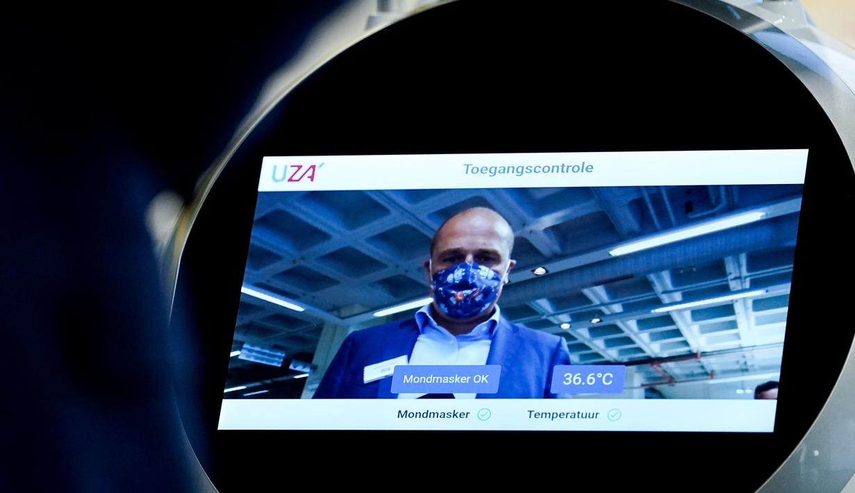 Seorang karyawan perusahaan Belgia, ZoraBots, menguji robot yang disebut CRUZR di Antwerp University Hospital (UZA) pada 29 Mei 2020. Robot ini dapat mendeteksi demam serta mengetahui pengunjung rumah sakit  yang memakai Masker atau tidak. (Kenzo TRIBOUILLARD/AFP)