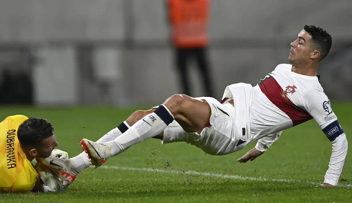 Striker Timnas Portugal, Cristiano Ronaldo berusaha merebut bola dari penguasaan kiper Slovakia, Martin Dubravka pada laga Grup J kualifikasi Euro 2024 di National Football Stadium, Bratislava, Slovakia, Sabtu (9/9/2023) dini hari WIB. (AP Photo/Radovan Stoklasa)