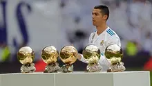 Bintang Real Madrid, Cristiano Ronaldo berpose dengan kelima trofi Ballon d'Or sebelum laga Real Madrid vs Sevilla di Stadion Santiago Bernabeu, Sabtu (9/12). Ronaldo baru saja meraih trofi kelima penghargaan Ballon d'Or 2017 di Paris. (AP/Francisco Seco)