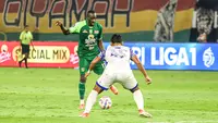 Striker Persebaya, Flavio Silva, mencoba melewati adangan pemain PSIS, Syiha Buddin, pada lanjutan BRI Liga 1 2024/2025 di Stadion Gelora Bung Tomo, Surabaya, Rabu (12/3/2025) malam WIB. (Bola.com/Aditya Wany)
